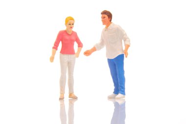 miniature people. figures of a man and a woman on a white background. communication and relationship building. problems in communication.