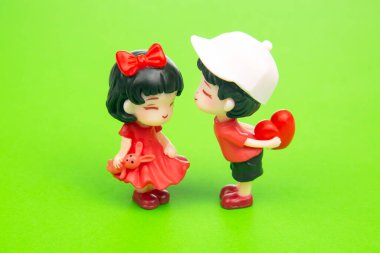 miniature people. figures for the game. romantic couple of young people. A boy lovingly gives his heart to a cute girl