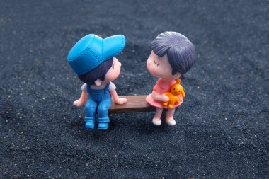 miniature people. figures for the game. romantic couple of young people. Boy and girl sitting on a bench