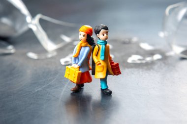 miniature people. a couple of people near a broken hourglass. crisis of personal relationships. concept of communication and dispute