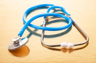stethoscope on a golden background. heart rate medical instrument