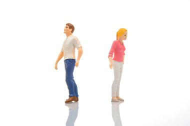miniature people. figures of a man and a woman on a white background. communication and relationship building. problems in communication.