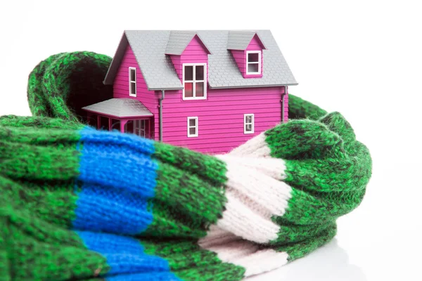 stock image house model is insulated with a knitted scarf on a white background. the concept of keeping warm and cozy indoors at home. cold protection