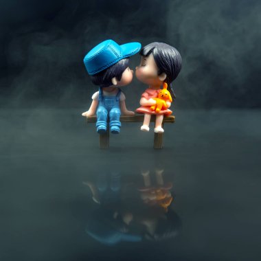 miniature people. figures for the game. romantic couple of young people. Boy and girl sitting on a bench