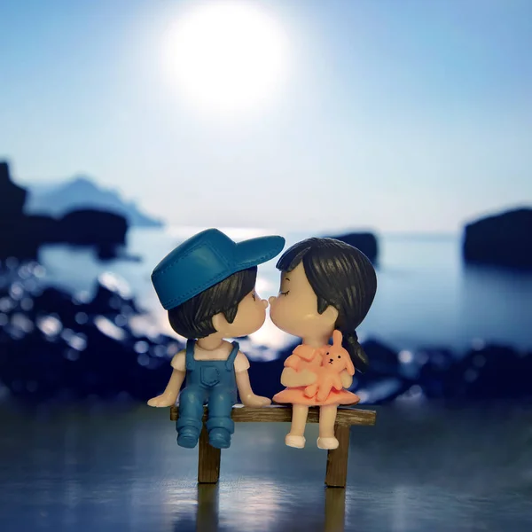 miniature people. figures for the game. romantic couple of young people. Boy and girl sitting on a bench