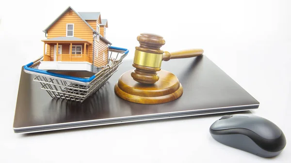 court hammer and auction on the background of a house model in a grocery basket and a laptop. legitimacy of real estate transactions. selling and buying a house