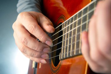 Klasik gitarla çalan müzisyenin elleri