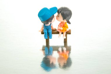 miniature people. figures for the game. romantic couple of young people. Boy and girl sitting on a bench