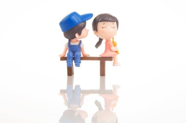 miniature people. figures for the game. romantic couple of young people. Boy and girl sitting on a bench