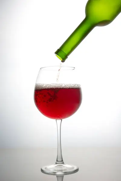 Vin Rouge Bouteille Est Versé Dans Verre Sur Fond Clair — Photo