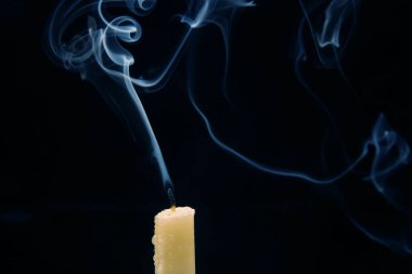 Karanlık bir arka planda sönmüş bir mumun dumanı. Maneviyat ve hayatın sonu kavramı..