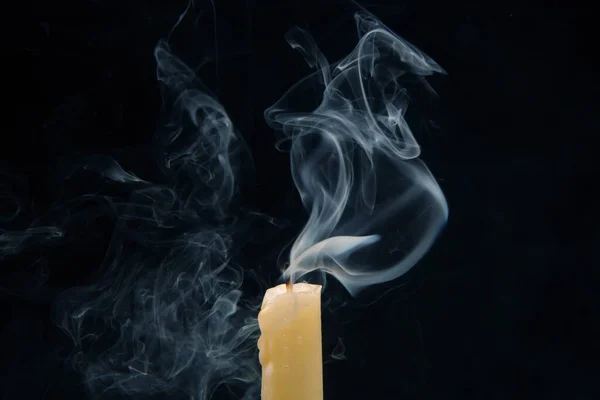 Smoke from an extinguished candle on a dark background. The concept of spirituality and the end of life.
