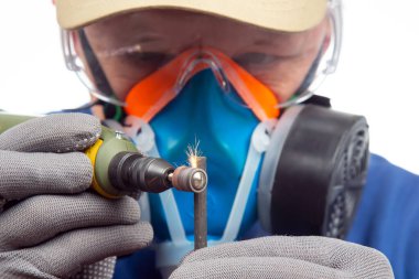 Erkek çilingir işçi, metali oymalı matkapla işliyor. Dremel oyma aletinin işi. Endüstriyel metal işleme endüstrisi