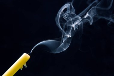 Karanlık bir arka planda sönmüş bir mumun dumanı. Maneviyat ve hayatın sonu kavramı..