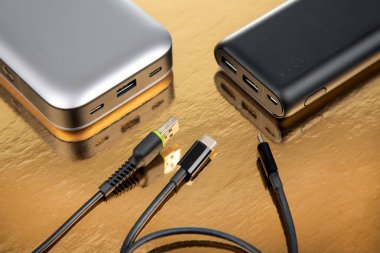 Altın arka planda taşınabilir Powerbank. Cihazları ve akıllı telefonları şarj etmek için elektronik aygıtlar