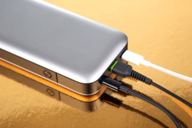 Altın arka planda taşınabilir Powerbank. Cihazları ve akıllı telefonları şarj etmek için elektronik aygıtlar