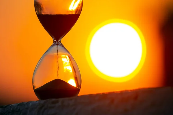 Hourglass on the background of a sunset. The value of time in life. An eternity.