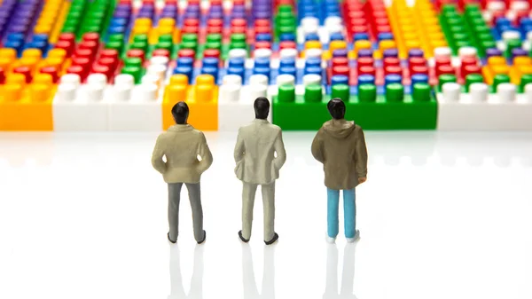 miniature people. figures of people stand near the colored plastic blocks of the designer. concept of business and industrial development. the concept of dreams and choice of life direction