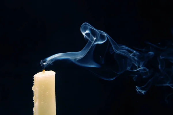 在黑暗的背景上从熄灭的蜡烛中冒出的烟 灵性的概念和生命的终结 免版税图库照片