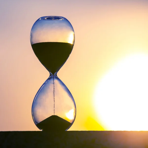 日没の背景に砂時計 人生の時間の価値 — ストック写真