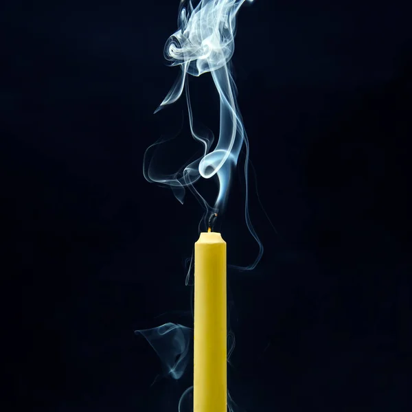 Smoke from an extinguished candle on a dark background. The concept of spirituality and the end of life.