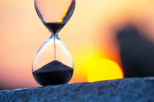 日没の背景に砂時計 人生の時間の価値 — ストック写真