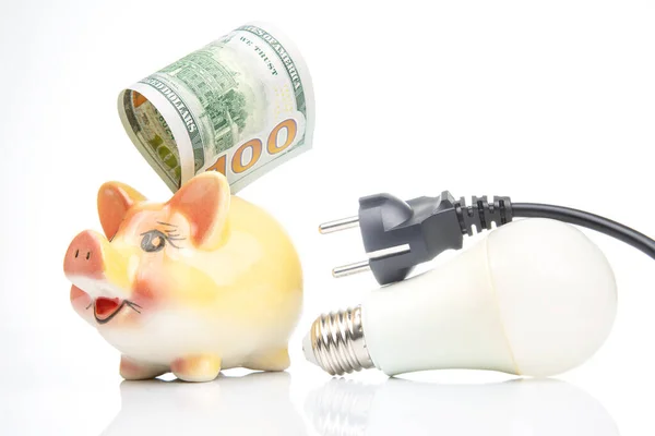 stock image Piggy bank, LED lamp and electric cable plug. Saving electricity. Energy saving concept