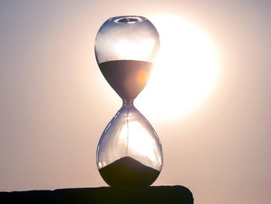 Kum saati, akşam güneşinin arka planına göre zamanın uzunluğunu sayar. Evrendeki yaşam süresinin akışkanlığı kavramı. zaman ve ışık