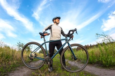 Sakallı erkek bisikletçi doğada bir bisikletle dinleniyor. bisiklet ve sağlık hobileri
