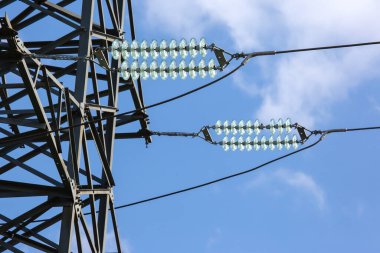Elektrik gerilim kablolarına sahip yüksek voltaj kulesi bulutların arka planına yakın çekim izole eder. Enerji endüstrisi.