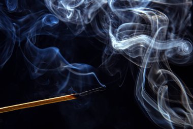 Siyah arka planda sigara eşleşmesi. Sıcaklık ve alevlerin ışığı