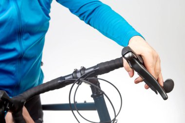 Bisikletçinin eli bisiklet direksiyonunun fren kolunda.