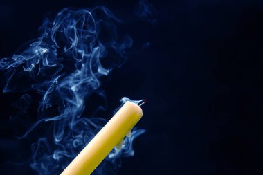 Karanlık bir arka planda sönmüş bir mumun dumanı. Maneviyat ve hayatın sonu kavramı..