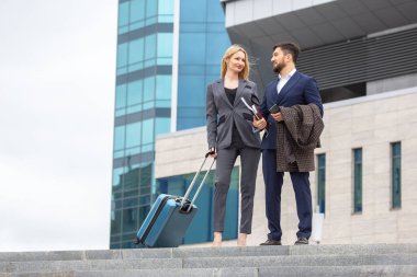 İş ve güven. İş adamları ve kadınlar bir ofis binasının arka planında iletişim kuruyor.