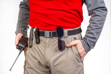 Telsiz, el feneri, turist yürüyüş pantolonunun kemerinde bıçak. Turizm ve seyahat ekipmanları. EDC ögeleri