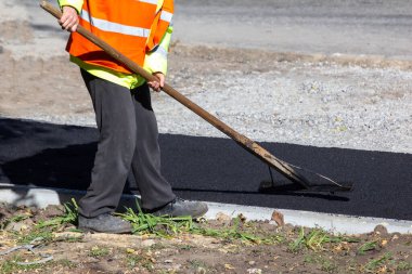 İşçiler kaldırıma yeni asfalt sermişler. yol endüstrisi