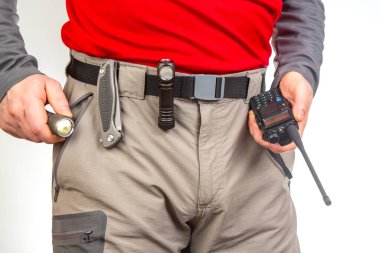 Telsiz, el feneri, turist yürüyüş pantolonunun kemerinde bıçak. Turizm ve seyahat ekipmanları. EDC ögeleri