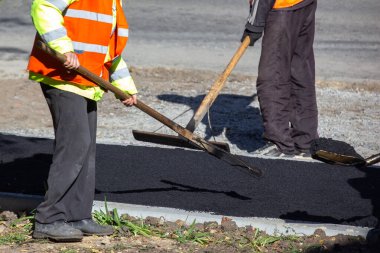 İşçiler kaldırıma yeni asfalt sermişler. yol endüstrisi