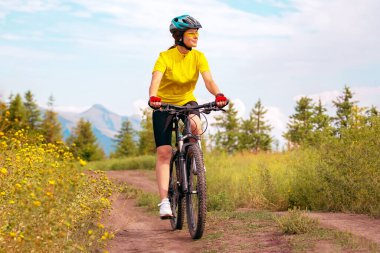 Güzel bir bisikletçi kadın doğada bisiklet sürüyor. Sağlıklı yaşam tarzı ve spor. Boş zaman ve hobiler.