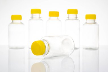 Işık arka planında beş şeffaf plastik şişe.