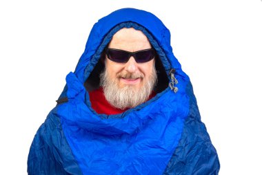 Beyaz arka planda uyku tulumunda sakallı bir adam. Turizm ve seyahatte dinlenme ekipmanları