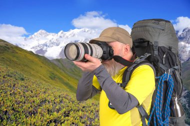 Sırt çantalı bir fotoğrafçı seyahatte doğanın güzelliğini fotoğraflıyor.