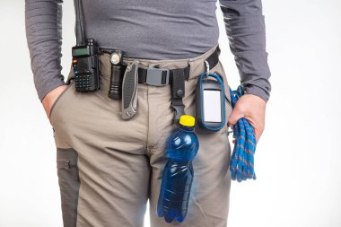 Su, telsiz, el feneri, bıçak, GPS navigatörü, turist yürüyüş pantolonunun kemerine tırmanma ipi. Turizm ve seyahat ekipmanları. EDC ögeleri