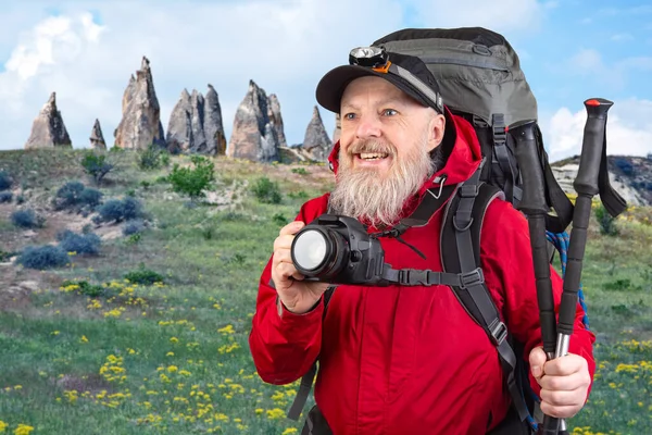 Sırt çantalı sakallı turist fotoğrafçı dağlardaki doğanın güzelliğini fotoğraflıyor. Dağlarda doğa yürüyüşleri