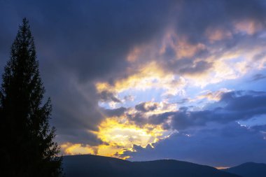 Gün batımından sonra canlı bir gökyüzü, koyu turuncu ve pembe renkler sakin bir alacakaranlık mavisi ile harmanlanarak sakin ve renkli bir akşam atmosferi yaratır.