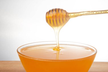 Taze kokulu bal bir kaşıktan bir tabağa damlıyor. Organik vitamin besin. Tatlı yemek.
