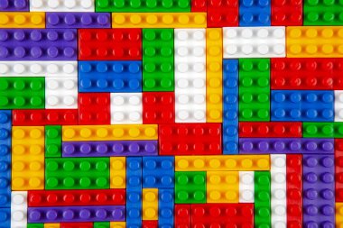 Renkli yapı bloklarının soyut arkaplan dokusu. İnşaatçının renkli plastik parçalarının arka planı. Renkli oyuncak yığınları..