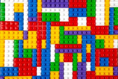 Renkli yapı bloklarının soyut arkaplan dokusu. İnşaatçının renkli plastik parçalarının arka planı. Renkli oyuncak yığınları..