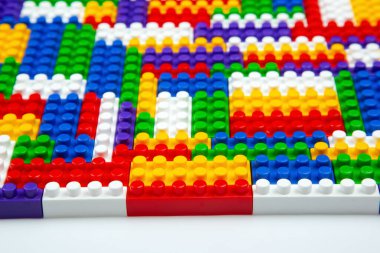 Renkli yapı bloklarının soyut arkaplan dokusu. İnşaatçının renkli plastik parçalarının arka planı. Renkli oyuncak yığınları..