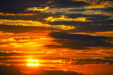 Gün batımından sonra gökyüzüne çarpan kırmızı ve turuncu renkli dinamik bir sıra yumuşak mor ve maviye karışıyor. Gün sona ererken bir huzur ve korku hissi uyandırıyor.